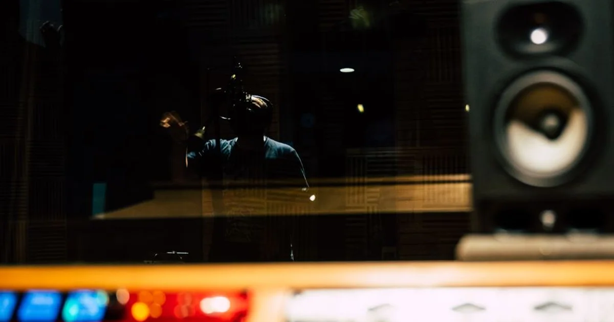 Nigerian voice actor in a professional recording studio with a microphone
