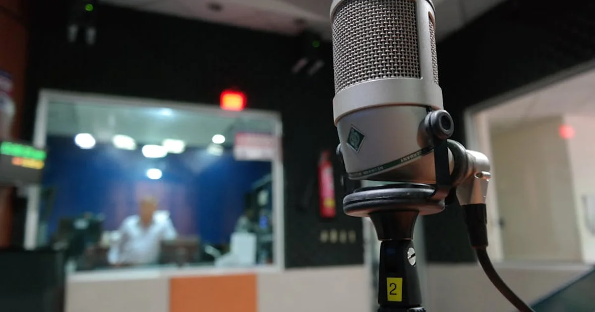 Nigerian voice actor in a professional home studio with a microphone